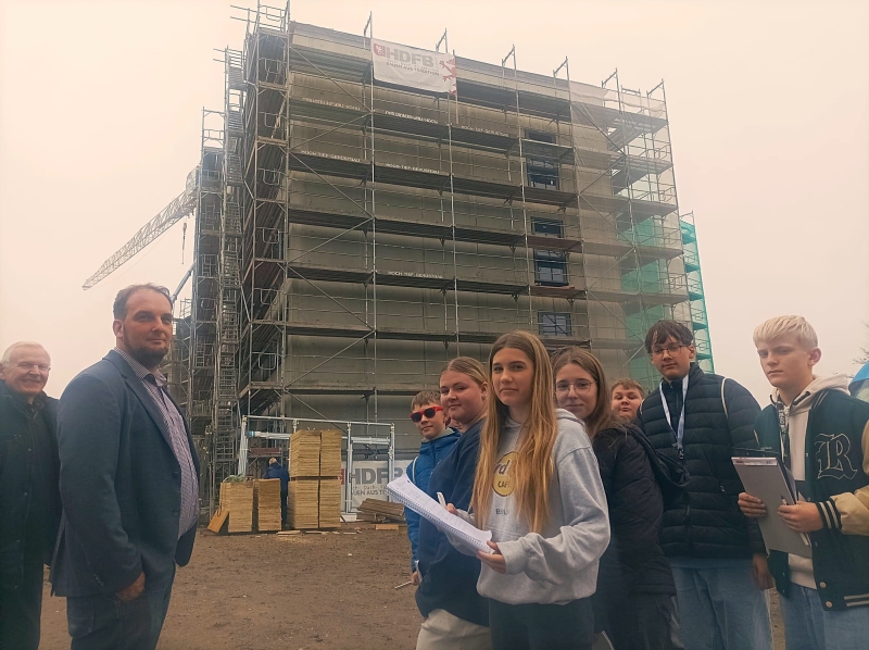 Bürgermeister Nico Last (links) führt eine kleine Schülergruppe über die Rohbaustelle der neuen Schule und weckt Neugierde und Nachfragen. Foto: André Farin