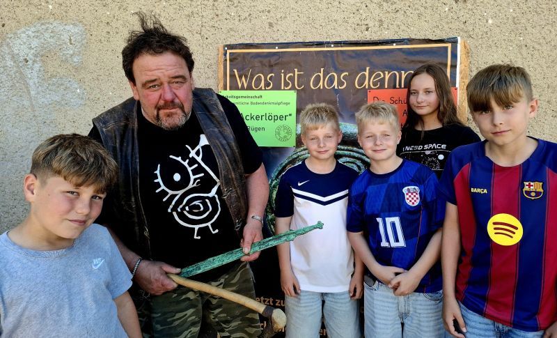 Rügens Denkmalpfleger zu Besuch in der Schule Gingst. Rene Schön (2. v. l.) erklärt Schülern der 5. Klassen seine Funde aus der Bronzezeit. Foto: André Farin