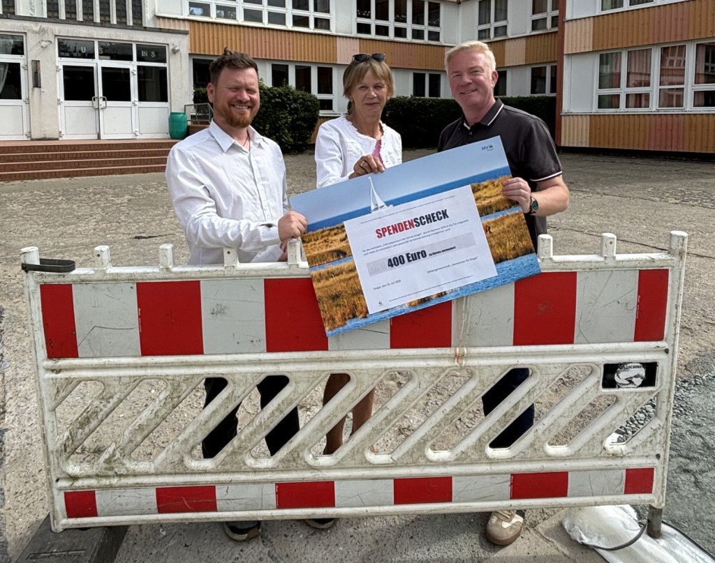 Clemens Oppermann (rechts) und Astrid Dürkoop (Mitte) übergeben an Schulleiter André Farin den Spendenscheck für den Fahrradparcours. Foto: Martina Zabel
