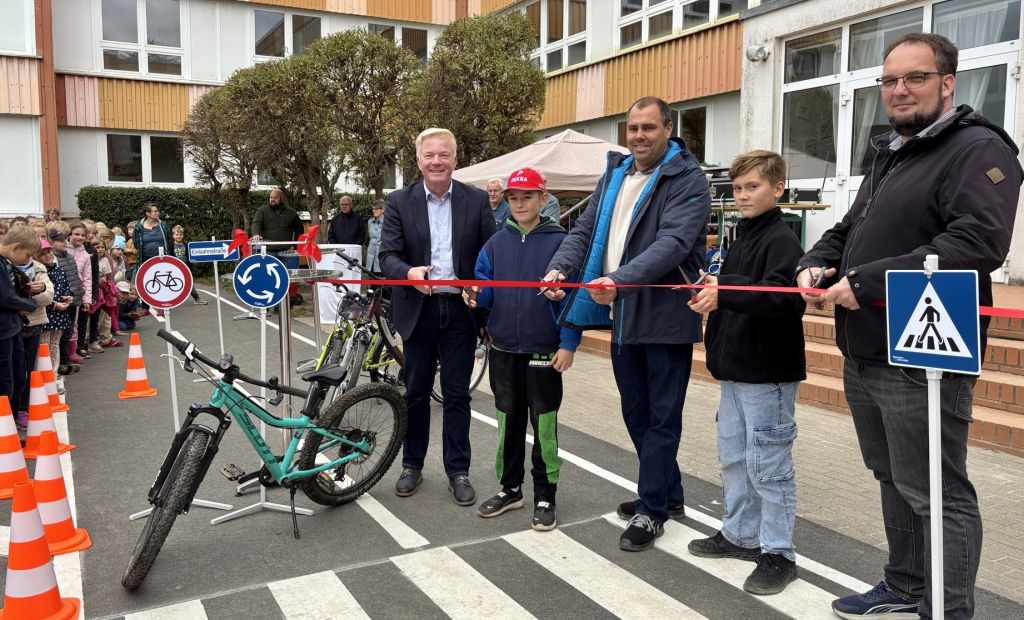 Bürgermeister Nico Last, Jakob Harder, Johannes Pingler von der TIEWA GmbH, Marco Schneider und Schulleiter André Farin (v. r. n. l.) durchschneiden das symbolische Band zur Eröffnung des Fahrradparcours in Gingst. Foto: Martina Zabel